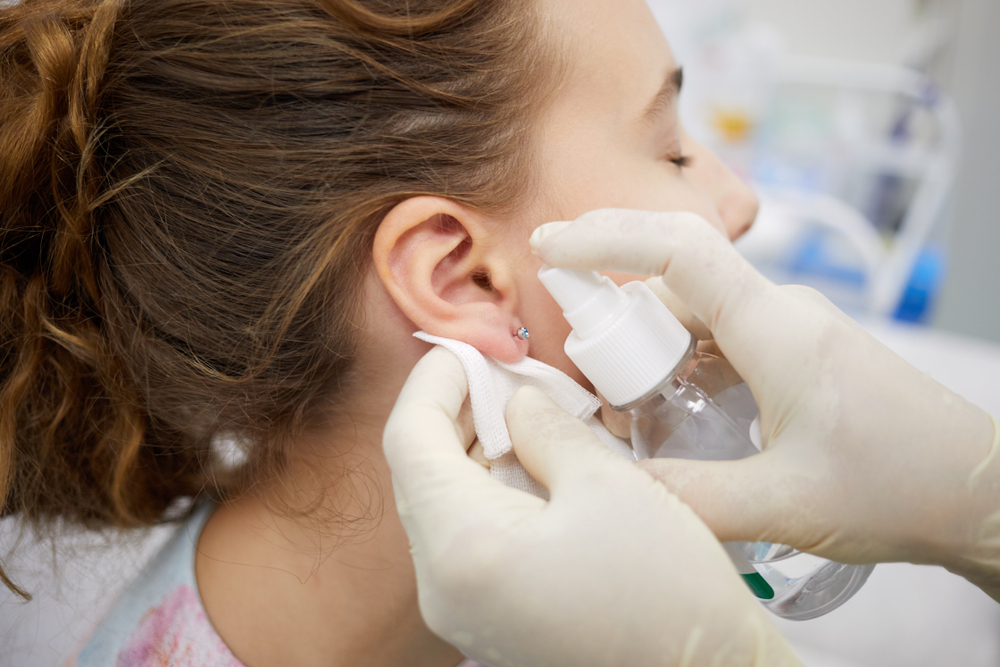doctor using sterile piercing earrings to avoid piercing infections doctor using sterile piercing earrings to avoid piercing infections