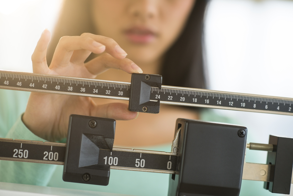 A woman measuring her weight A woman measuring her weight