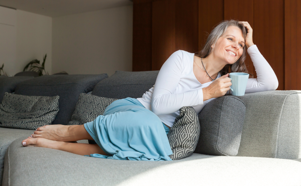 A woman relaxing on the couch to reduce menopausal fatigue A woman relaxing on the couch to reduce menopausal fatigue