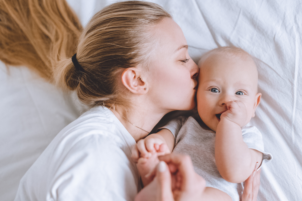 A woman trying to to soothe her teething infant A woman trying to to soothe her teething infant