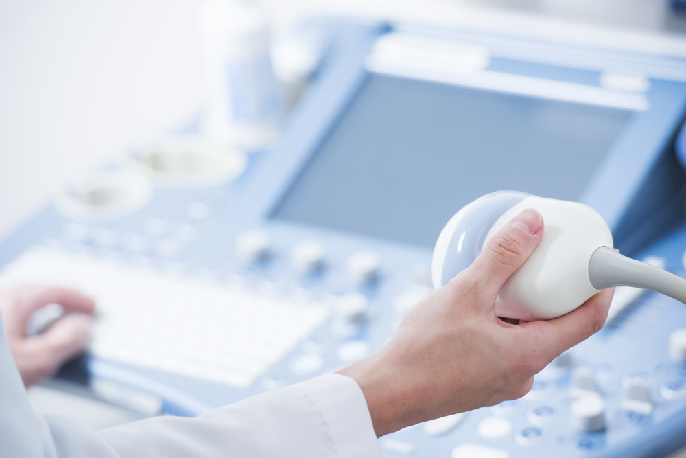 doctor's hands close up preparing for an ultrasound device scan