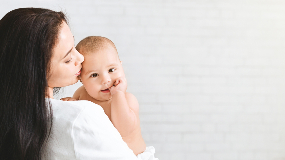 A woman trying to stop her baby from eating their fingernails A woman trying to stop her baby from eating their fingernails