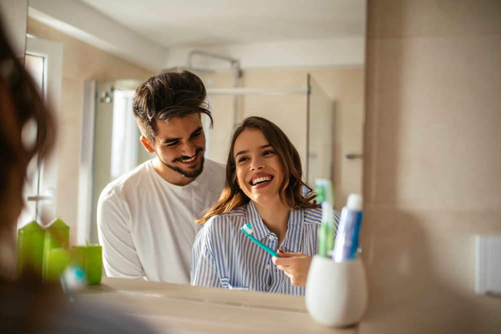 A couple brushing theit teeth with fluoride-free toothpaste A couple brushing theit teeth with fluoride-free toothpaste