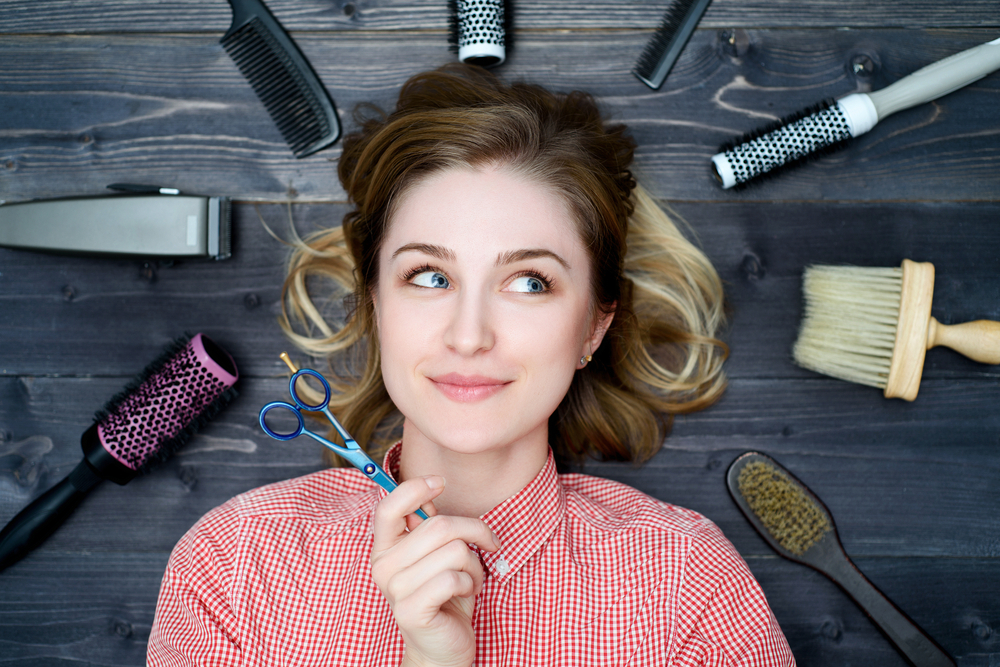 young woman in plaid shirt with scissors in hand and hairdresser tools young woman in plaid shirt with scissors in hand and hairdresser tools