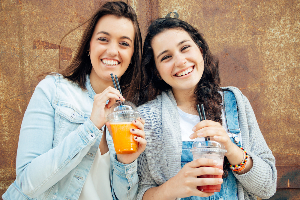 Girls drinking smoothies, which are a healthy snack to keep at home Girls drinking smoothies, which are a healthy snack to keep at home