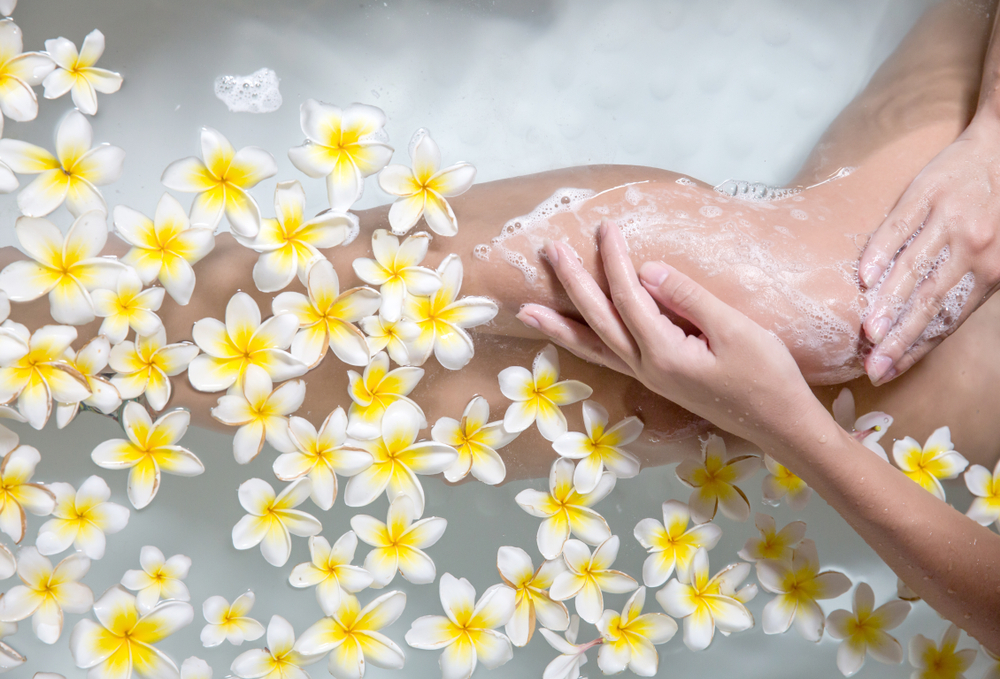 A woman washing her legs with soap an water to treat chafed skin A woman washing her legs with soap an water to treat chafed skin
