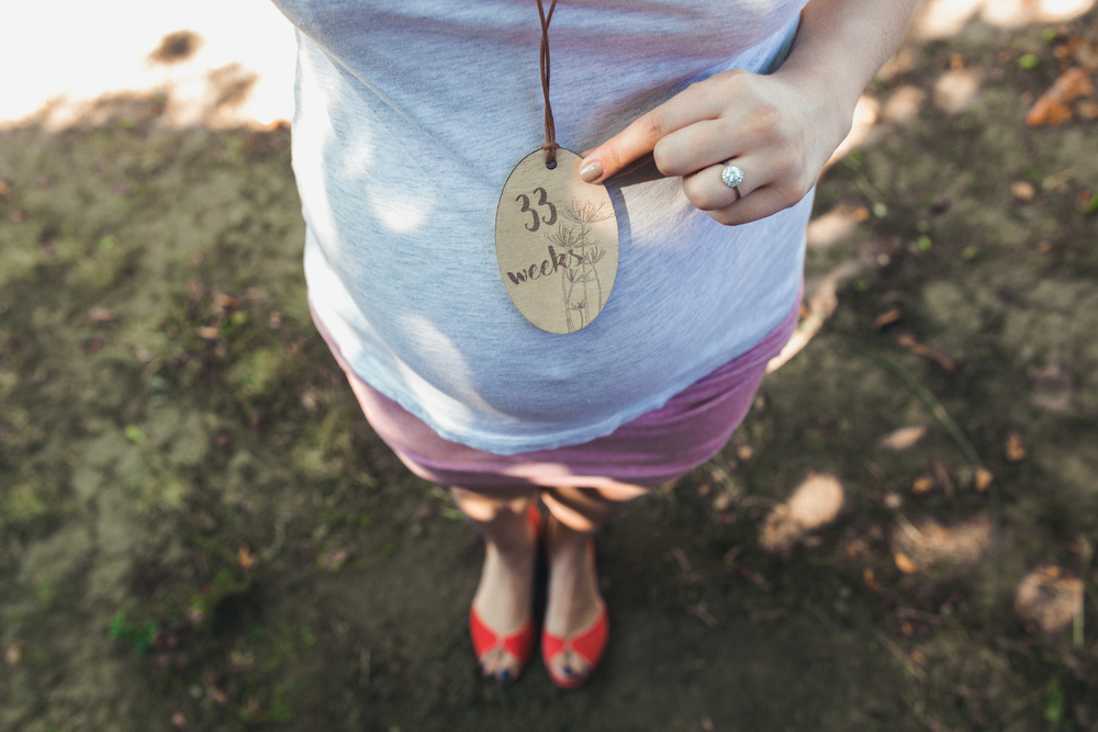 Pregnant woman's belly with a close angle in the park