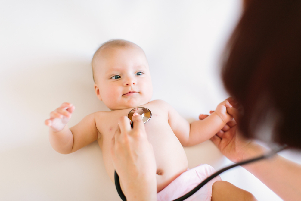 A GP is using a stethoscope to listen to baby's breathing A GP is using a stethoscope to listen to baby's breathing