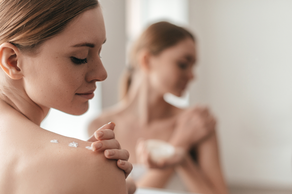 A woman applies moisturizer after taking a bath A woman applies moisturizer after taking a bath