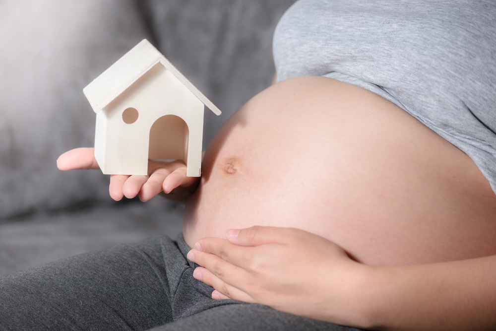 pregnant woman with model home on her belly pregnant woman with model home on her belly
