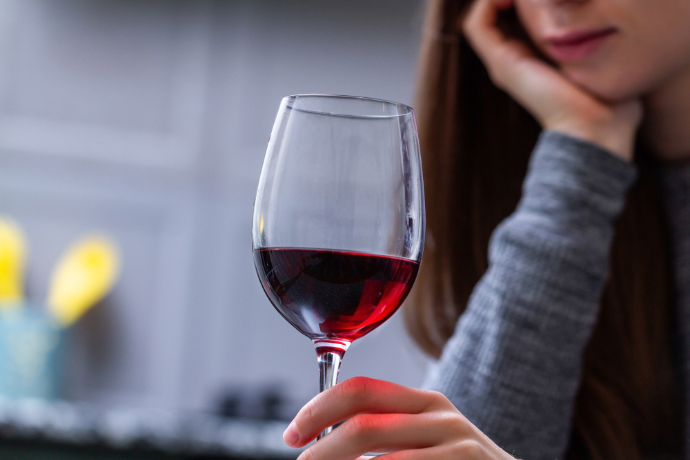 A woman thinking whether alcohol thins the blood A woman thinking whether alcohol thins the blood