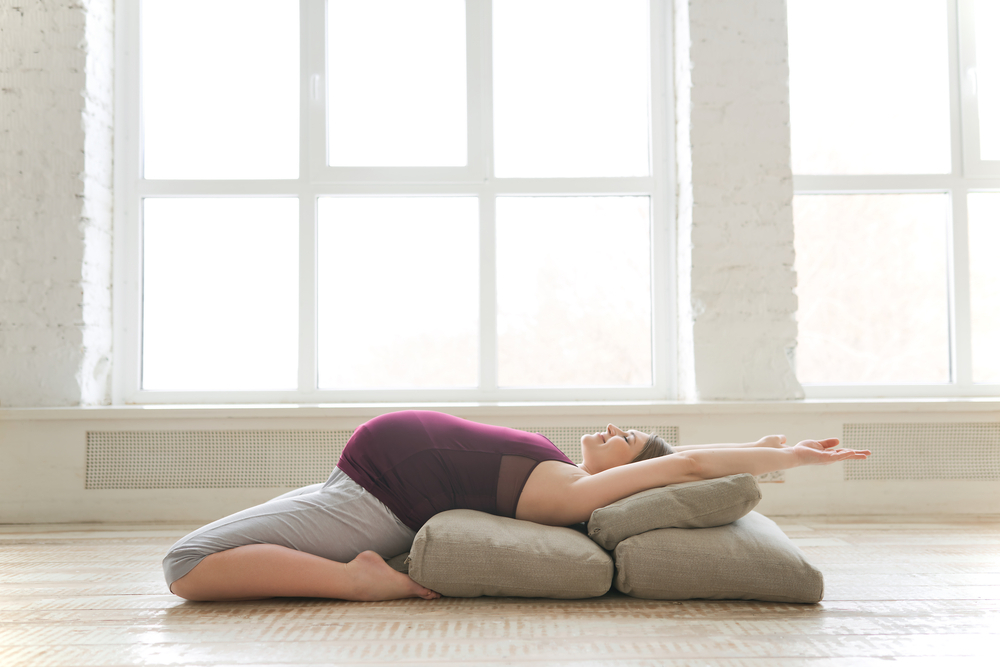 Pregnant woman stretching with pillows support Pregnant woman stretching with pillows support
