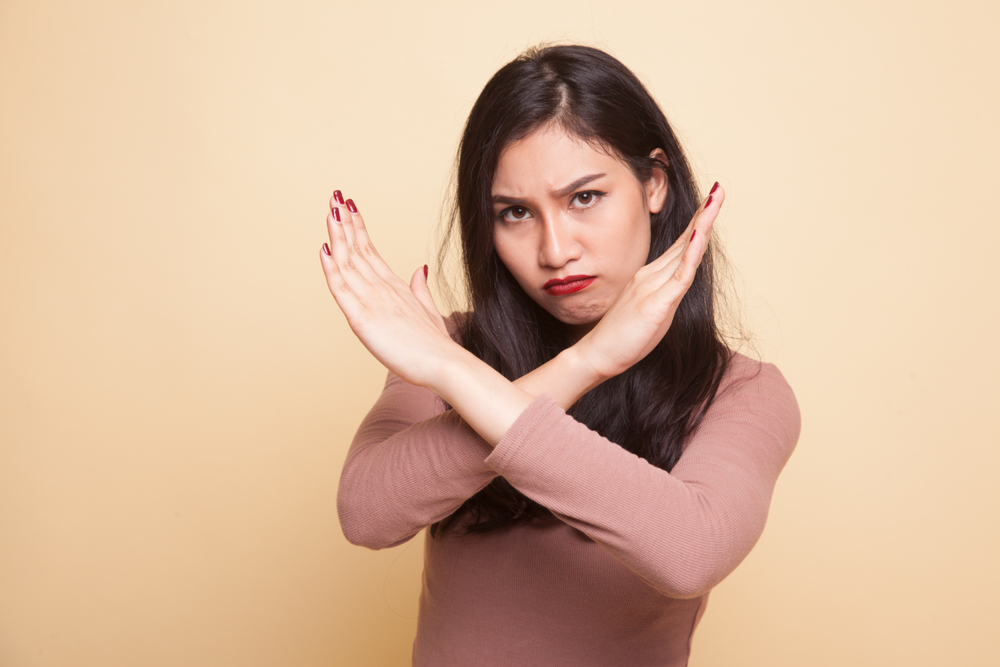 young Asian woman say no on beige background young Asian woman say no on beige background