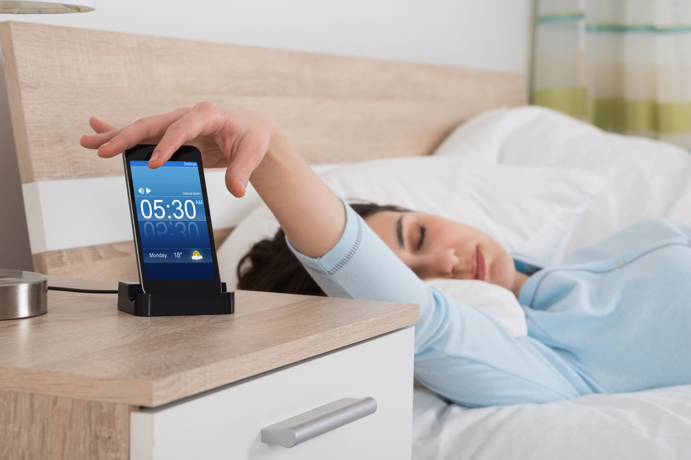 A woman swithching off an alarm A woman swithching off an alarm