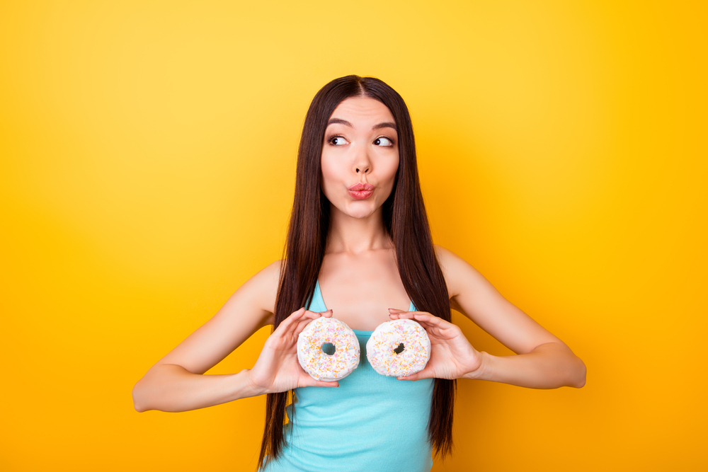 girl is holding donuts near her breasts girl is holding donuts near her breasts