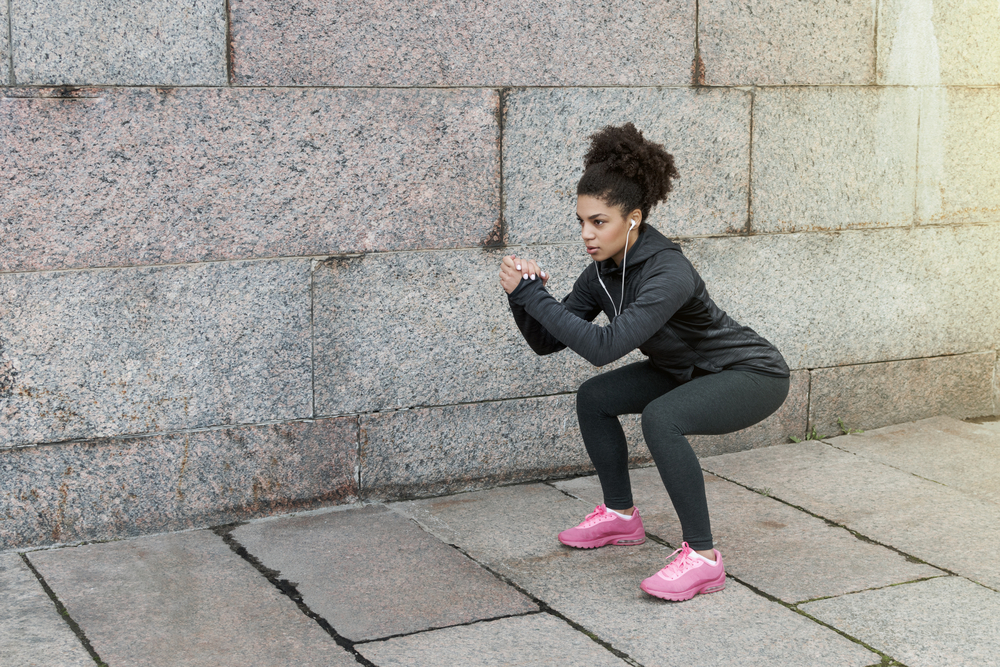 A woman doing squats to lose thigh fat A woman doing squats to lose thigh fat