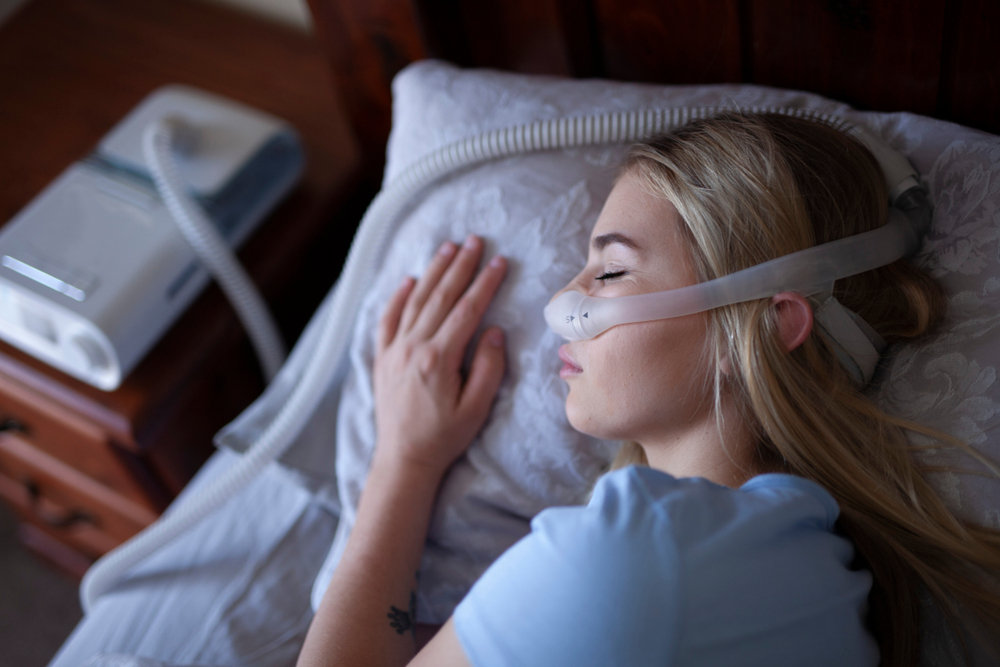 A woman sleeping with CPAP machine A woman sleeping with CPAP machine