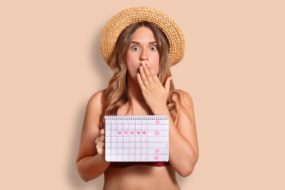 A woman calculating her cycle and wearing period swimwear A woman calculating her cycle and wearing period swimwear