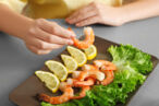 A pregnant women eats shrimp