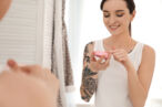 woman applies moisturizer to reduce the healing time for her new tattoo