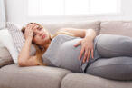 A woman suffering from stomach pain during pregnancy