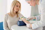 A nurse takes a blood sample from a female with fertility problems
