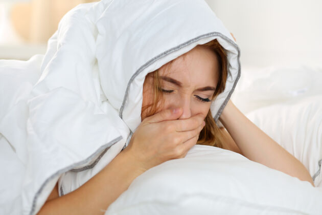 woman lying in bed suffering from morning sickness