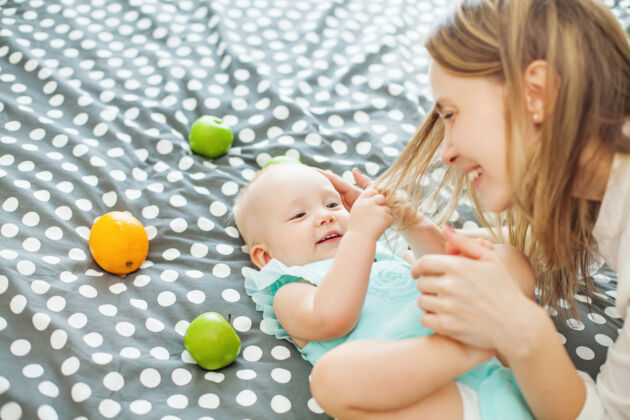 A woman trying to stop a baby from pulling her hair A woman trying to stop a baby from pulling her hair